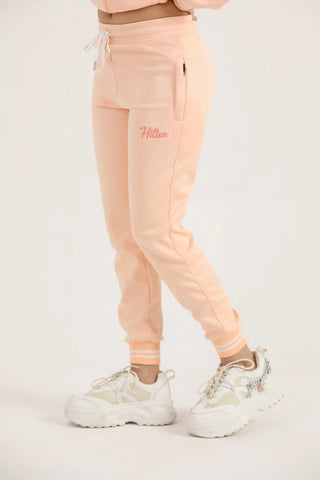 Hilton Aesthetics Women's Classic Zipper Joggers front view in peach with tapered fit and zip pockets