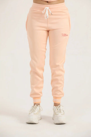 Hilton Aesthetics Women's Classic Zipper Joggers front view in peach with tapered fit and zip pockets