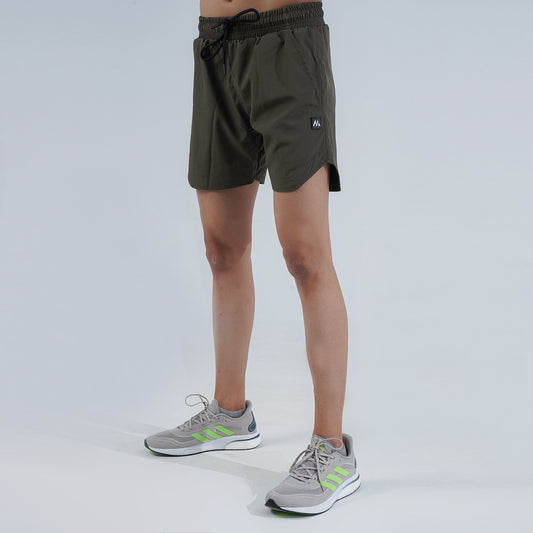 Front/angled view: Man wearing dim grey Hilton Aesthetics Performance Gym Shorts, front angled view
