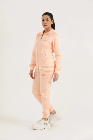 Full-length view of woman wearing a peach Hilton Aesthetics zip-up jacket and joggers