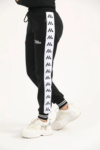 Side view of women's black classic zipper joggers with side logo panel and zip pocket