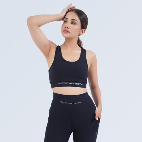 Model wearing the black Impact Sports Bra by Hilton Aesthetics in a front three-quarter pose