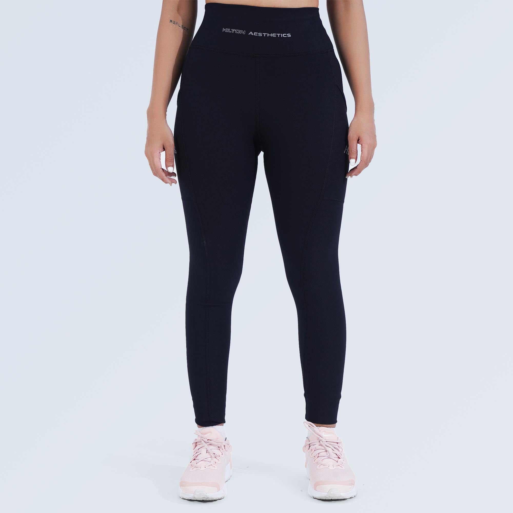 Woman wearing black high-waist pocket leggings by Hilton Aesthetics, front view