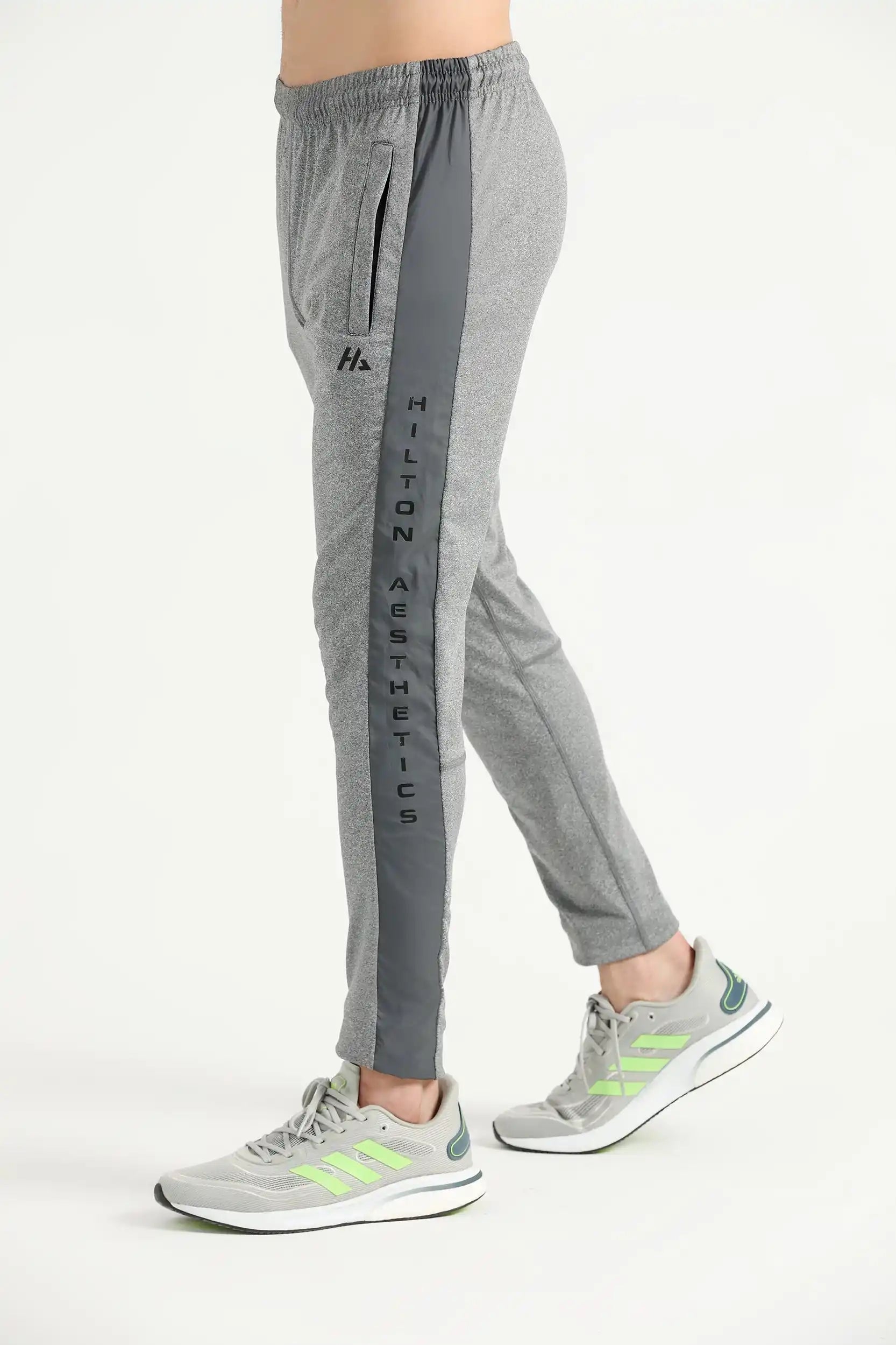 Man wearing grey Hilton Aesthetics Elite Joggers with tapered legs, side view