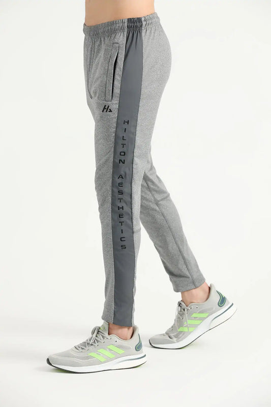 Man wearing grey Hilton Aesthetics Elite Joggers with tapered legs, side view