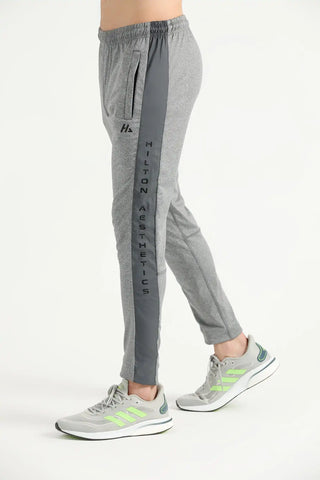 Man wearing grey Hilton Aesthetics Elite Joggers with tapered legs, side view