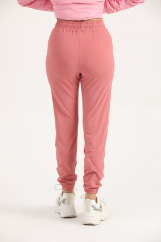 Women’s light coral Trace Joggers with a tapered athletic fit, back view