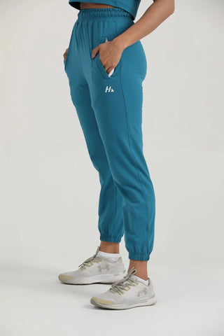 Side view of Hilton Aesthetics Trace Joggers in teal featuring lightweight performance fabric and athletic fit.