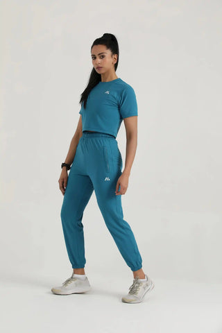 Model wearing Hilton Aesthetics Trace Joggers in teal, designed for workouts, fitness, and casual comfort.
