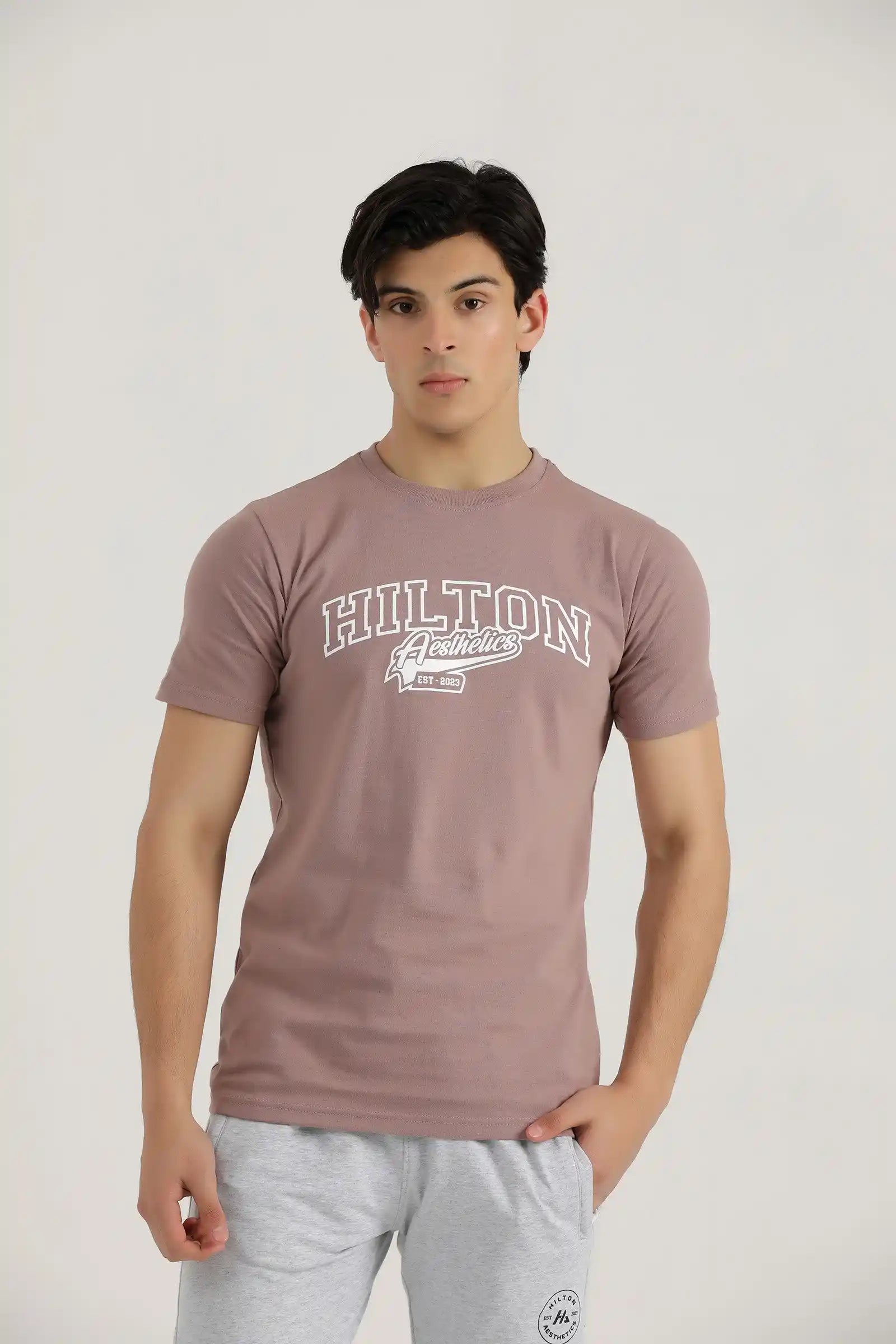 Man wearing a rosy brown Hilton Aesthetics Vital cotton T-shirt, front view