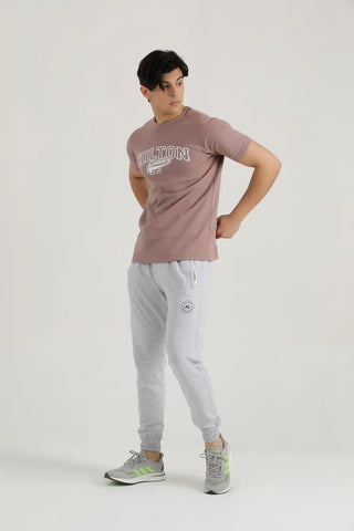 Man modelling a rosy brown Vital T-shirt with light grey joggers, three-quarter view