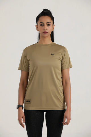 Person wearing a beige t-shirt with a logo on a plain background