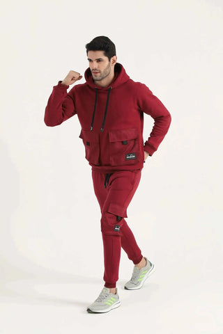Man wearing a burgundy Crest Cargo Hoodie and matching joggers, full-body side view