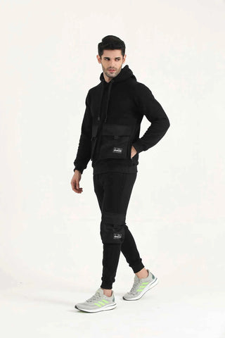 Man wearing black Hilton Aesthetics Crest Cargo Joggers with tapered fit, three-quarter view