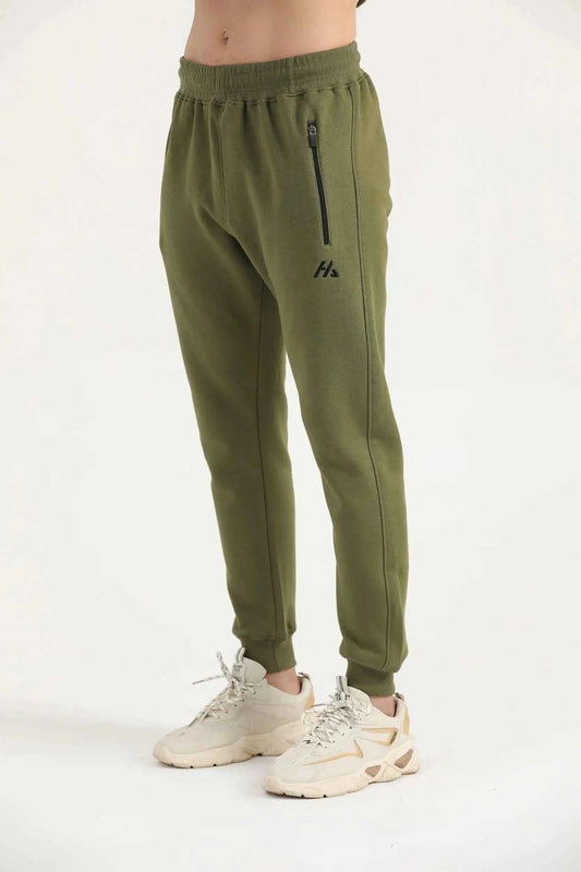Man wearing dark olive green Hilton Aesthetics Flexx Joggers, side view