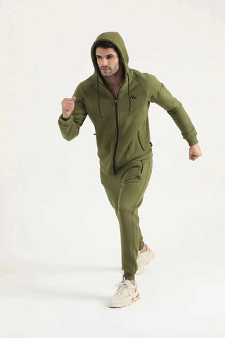 Man wearing dark olive Hilton Aesthetics Flexx Zip-Up Hoodie, full-length angled view