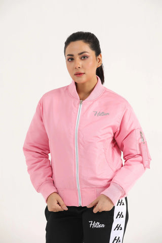 Woman wearing light pink Hilton Aesthetics Quilted Bomber Jacket, angled front view